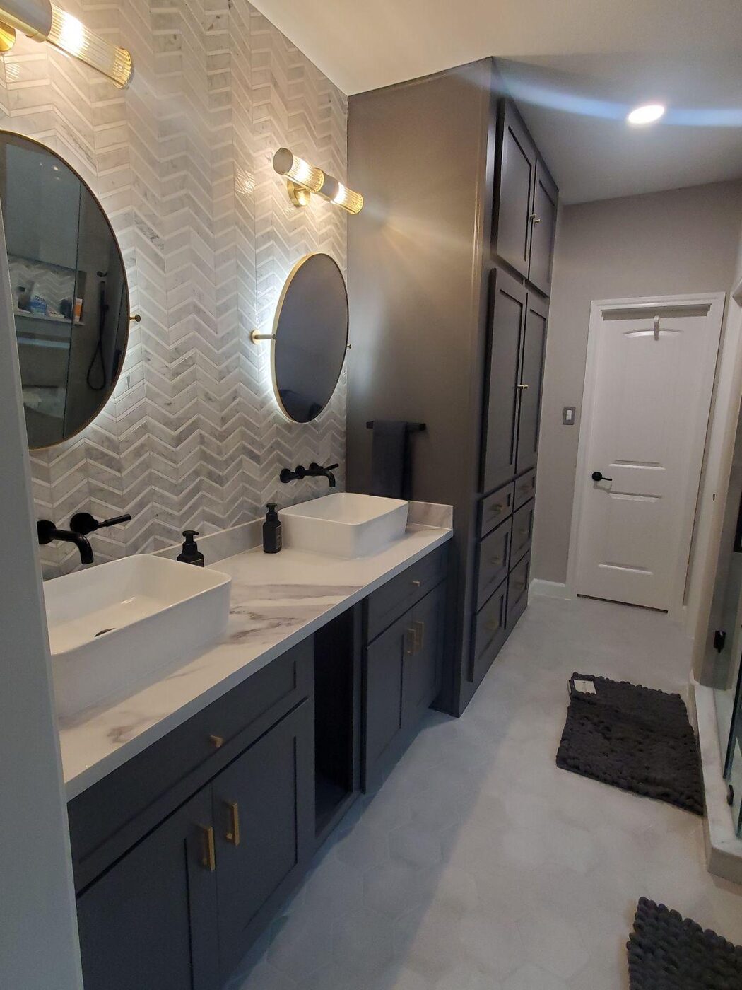 Moody dual vanity with a chevron marble accent wall