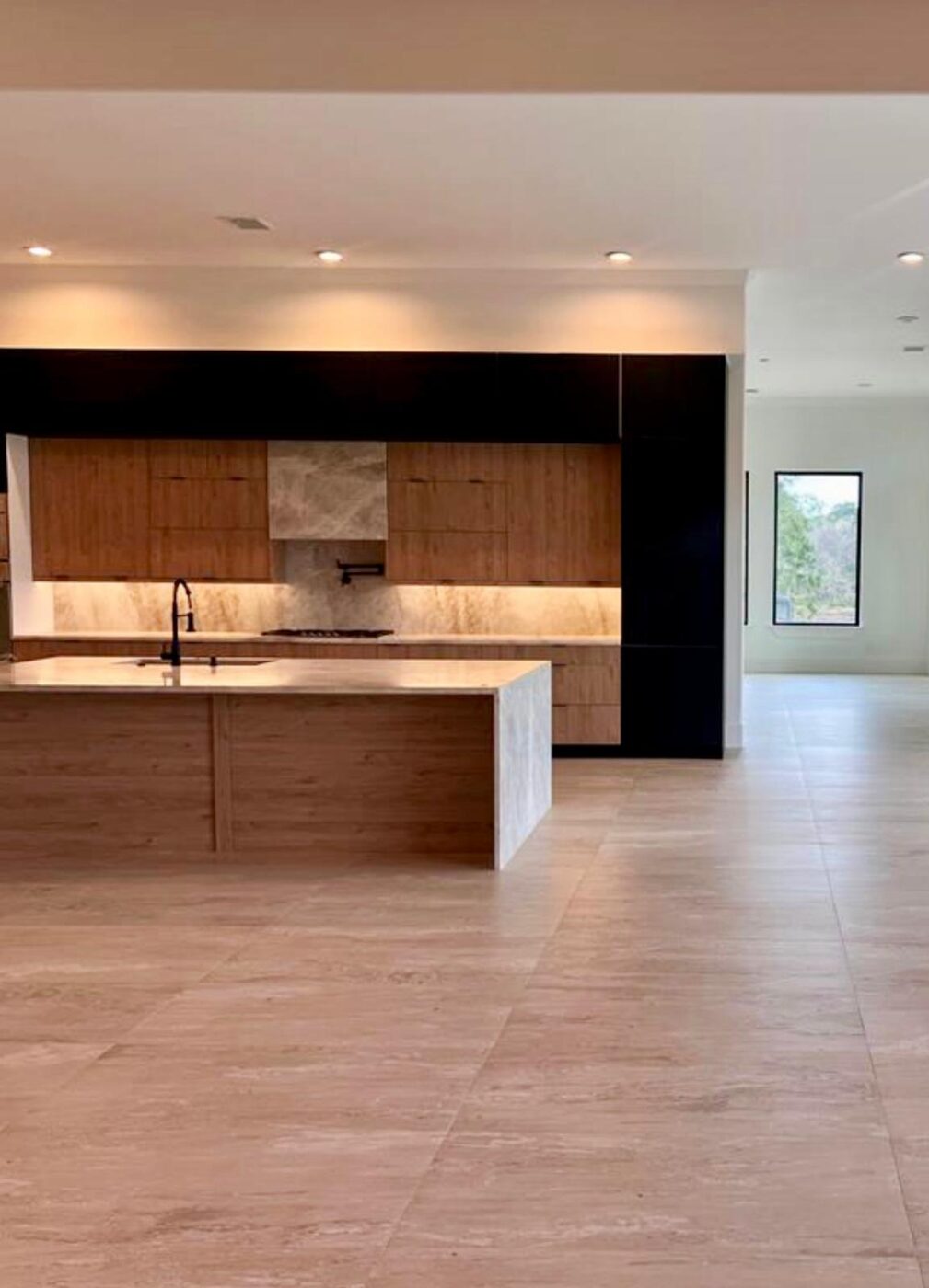 Two-tone kitchen with a floating stone hood and open sightlines