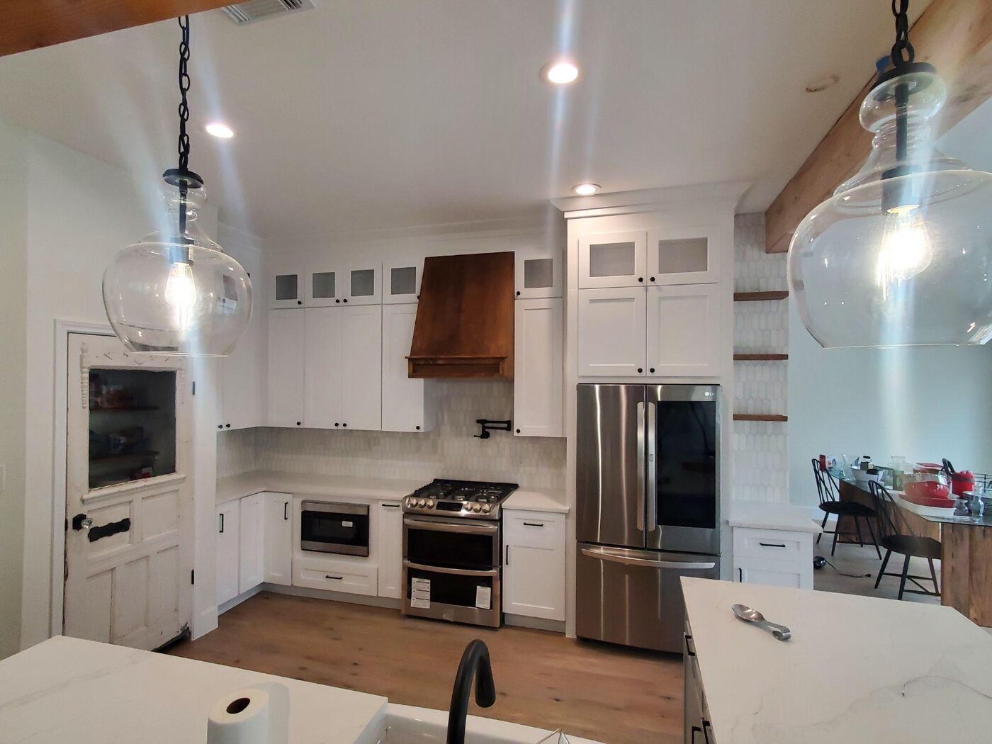 White shaker cabinetry with a copper vent hood accent
