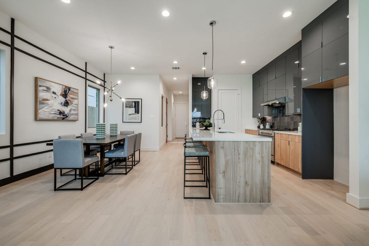 Matte black cabinetry with a warm-wood waterfall island