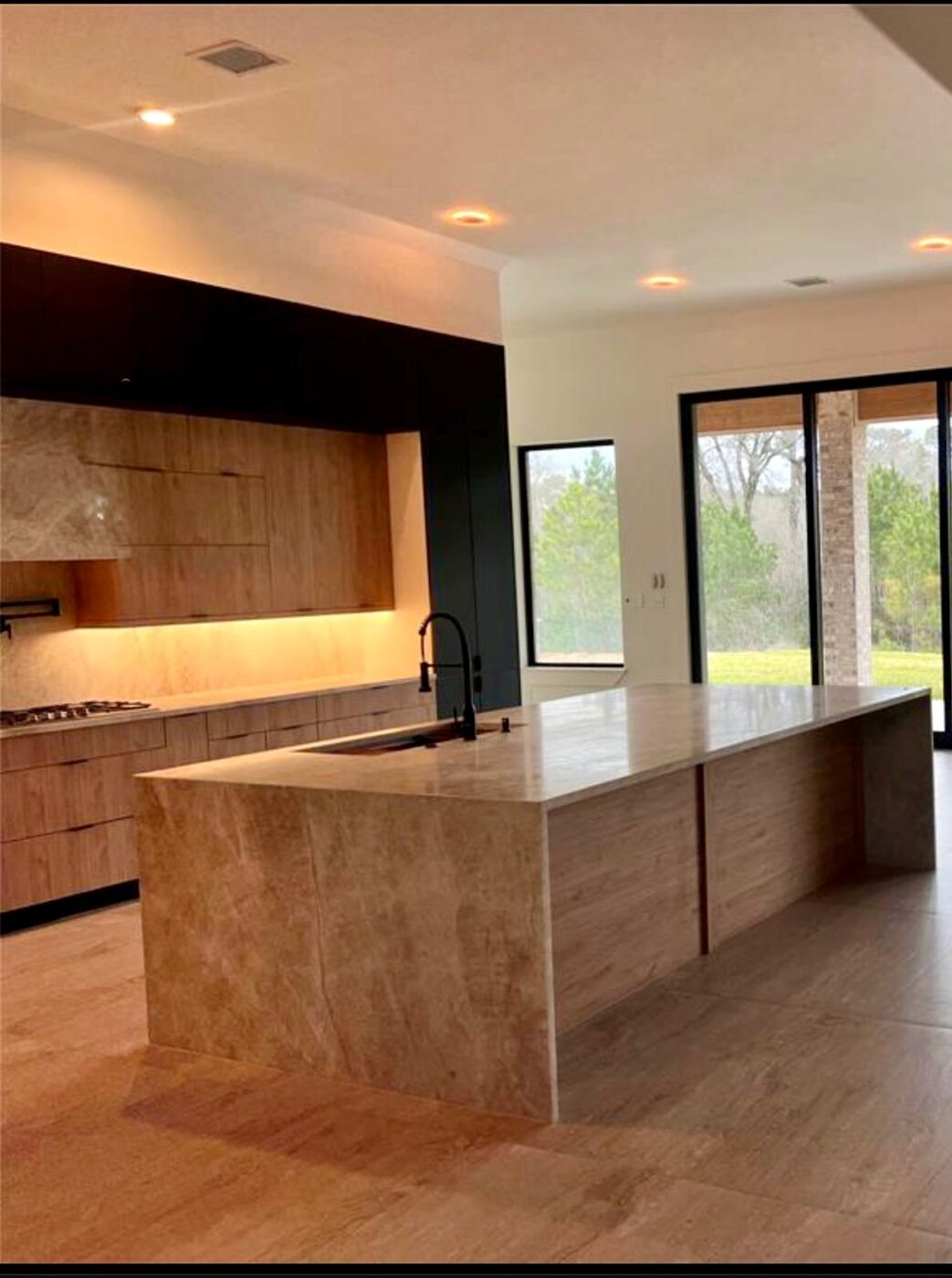 Open-concept kitchen and dining in a glossy graphite palette